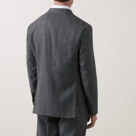 Model wearing Hugo dark grey suit jacket, rear view, styled with matching trousers and white shirt, single vent, tailored fit