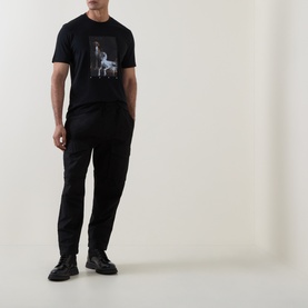 Model wearing Hugo black cotton T-shirt with graphic print, styled with black tapered trousers and black chunky boots