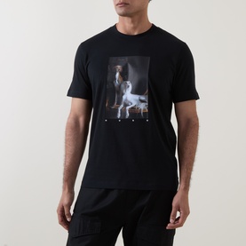 Model wearing Hugo black cotton T-shirt with large photographic dog and figure graphic print to chest.