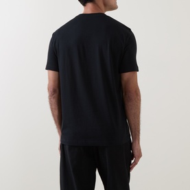 Model wearing Hugo black cotton T-shirt, rear view, styled with black trousers