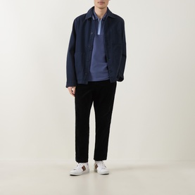 Model wearing Paul Smith navy cotton casual jacket, styled with blue polo shirt, black trousers and white trainers.