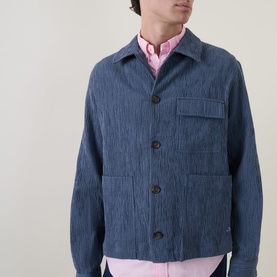 Model wearing Paul Smith blue cotton casual jacket with chest pocket and button front, styled with pink shirt underneath.