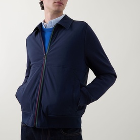 Model wearing Paul Smith Navy Casual Jacket with multicolour zip detail, styled with a light blue shirt and blue crew-neck jumper.