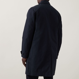 Model wearing Paul Smith Showerproof Car Coat in navy, rear view showing straight hem, rear vent, and longline silhouette.