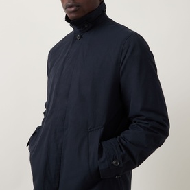 Model wearing Paul Smith Showerproof Car Coat in navy, showing concealed front fastening, funnel neck and welt pockets