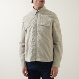 Model wearing Paul Smith Technical Harrington Jacket in brown, zip fastening, chest pocket, pointed collar, styled with navy trousers