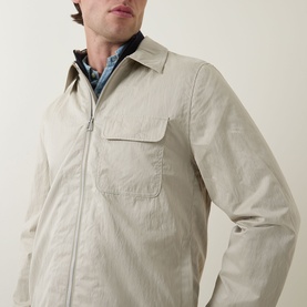 Model wearing Paul Smith Technical Harrington Jacket in brown, showing zip fastening, press stud chest pocket and pointed collar, styled over blue