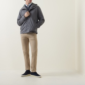 Model wearing Paul Smith grey casual jacket with hood, styled with beige chinos and navy suede trainers.