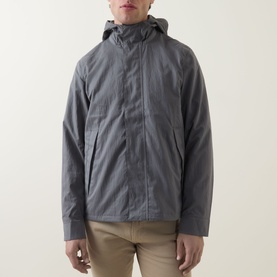 Model wearing Paul Smith grey casual jacket with hood, zip fastening, styled with beige trousers.