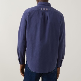 Model wearing Paul Smith navy casual shirt, rear view, with signature stripe collar detail and blue jeans visible.