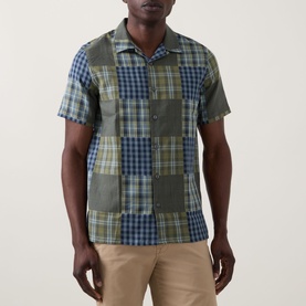 Model wearing Paul Smith Patchwork Check Shirt in green and navy, camp collar, short sleeves, styled with beige chinos.