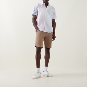 Model wearing Paul Smith White Stripes casual shirt in cotton-linen blend, styled with tan chino shorts and white trainers.