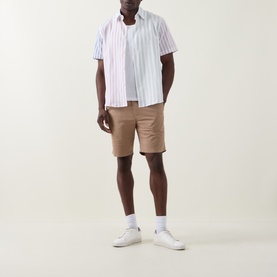 Model wearing Paul Smith White Stripes casual shirt with short sleeves, styled with tan chino shorts and white trainers.