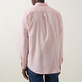 Model wearing Paul Smith pink casual shirt, rear view, styled with dark blue jeans. Long sleeves with button cuffs.