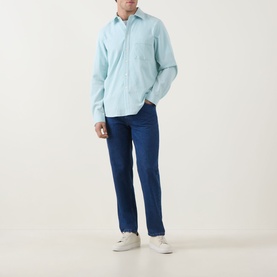 Model wearing Paul Smith Textured Stripe Shirt in green with classic collar and chest pocket, styled with navy jeans and white trainers.