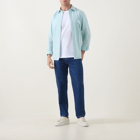 Model wearing Paul Smith Textured Stripe Shirt in green with classic collar and chest pocket, styled with navy trousers and white trainers.