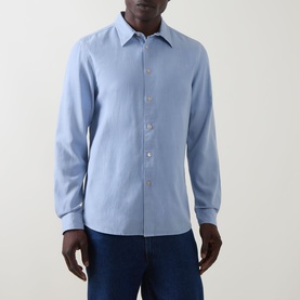 Model wearing Paul Smith Single-Cuff Shirt in blue, styled with dark jeans. Pointed collar, button fastening, long sleeves.