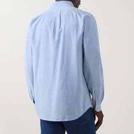 Model wearing Paul Smith Single-Cuff Shirt in blue, back view showing box pleat detail, styled with dark blue jeans.