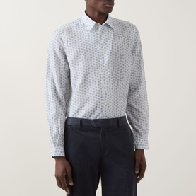 Model wearing Paul Smith white casual shirt with small all-over print, styled with dark navy trousers.