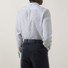 Model wearing Paul Smith white casual shirt with blue floral print, styled with navy trousers. Rear view.