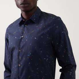 Model wearing Paul Smith Casual Abstract Print Shirt in navy with multicolour abstract print, point collar, and long sleeves with buttoned cuffs.