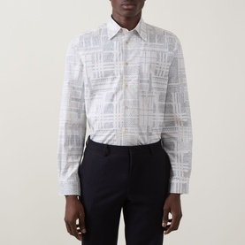 Model wearing Paul Smith white casual shirt with tonal check print, styled with navy tailored trousers.