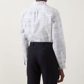 Model wearing Paul Smith white casual shirt with tonal geometric print, styled with navy trousers. Rear view.