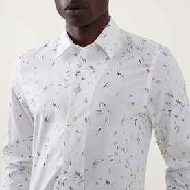Model wearing Paul Smith Casual Abstract Print Shirt in white with multicolour scattered abstract print, point collar, and long sleeves.