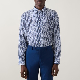 Model wearing Paul Smith blue geometric print casual shirt, styled with matching blue tailored trousers.