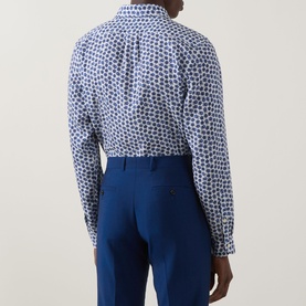 Model wearing Paul Smith blue geometric-print casual shirt, shown from behind, styled with navy tailored trousers.