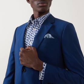 Model wearing Paul Smith blue casual shirt with floral print, styled with a navy blazer and matching pocket square
