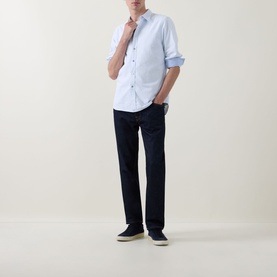 Model wearing Paul Smith blue cotton casual shirt with sleeves rolled up, styled with dark navy jeans and navy canvas shoes