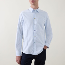 Model wearing Paul Smith blue cotton casual shirt with button-down front, styled with dark navy jeans.