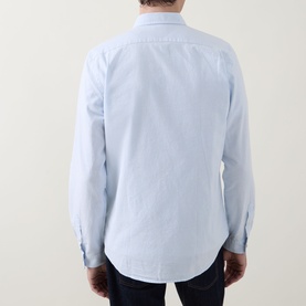 Model wearing Paul Smith blue cotton casual shirt, rear view showing clean back seam and button cuffs, styled with dark trousers