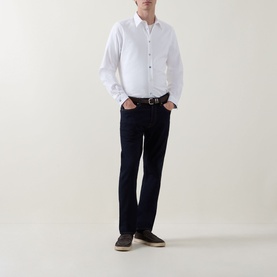 Model wearing Paul Smith Grey Mid-Rise Slim Fit Tapered Leg Jeans with white shirt and brown belt. Five-pocket style with concealed fastening.