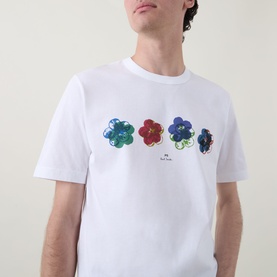 Model wearing Paul Smith white crew neck T-shirt with three floral graphic prints in green, red and blue on chest.