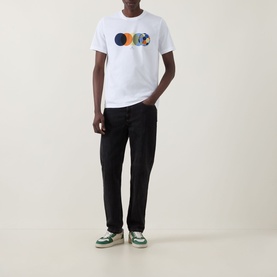 Model wearing Paul Smith Football Graphic Logo T-Shirt in white with black trousers and green-white trainers
