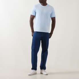 Model wearing Paul Smith Logo Faded T-Shirt in blue, crew neck, short sleeves, styled with navy trousers and white trainers.