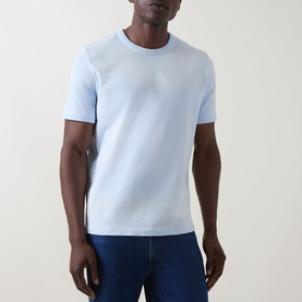 Model wearing Paul Smith Logo Faded T-Shirt in blue, crew neck, short sleeves, styled with dark denim jeans.