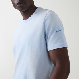 Model wearing Paul Smith Logo Faded T-Shirt in blue, crew neck, short sleeves, with embroidered logo detail on sleeve.