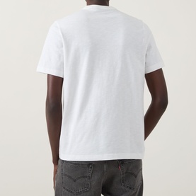 Model wearing Paul Smith Stripe Logo T-Shirt in white, rear view, crew neck, short sleeves, styled with dark grey jeans.