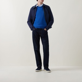 Model wearing Paul Smith Blue Zebra Badge Logo Crew Neck Sweater, styled with a navy bomber jacket, dark jeans and navy trainers.