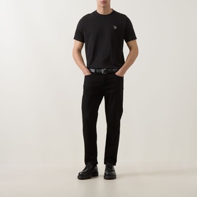 Model wearing Paul Smith black crew neck T-shirt with zebra logo, styled with black jeans and black leather shoes.