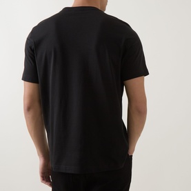 Model wearing Paul Smith black cotton crew neck T-shirt, back view, paired with black trousers.