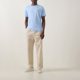 Model wearing Paul Smith Blue Crew Neck T-shirt with small chest logo, styled with cream trousers and white trainers.