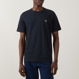 Model wearing Paul Smith blue crew neck T-shirt with embroidered zebra logo patch on chest, styled with dark jeans.