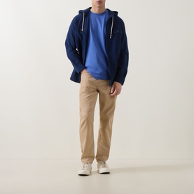 Model wearing Paul Smith Zebra Badge T-Shirt in blue with navy hooded jacket, styled with beige chinos and white trainers.