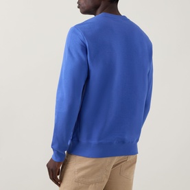 Model wearing Paul Smith Zebra Logo Sweatshirt in blue, crew neck, ribbed trims, back view, styled with beige trousers.