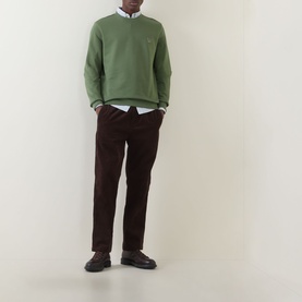 Model wearing Paul Smith Zebra Logo Green Crew Neck Sweatshirt with white shirt, dark corduroy trousers and black leather shoes.