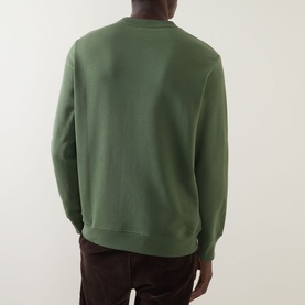 Model wearing Paul Smith Zebra Logo Sweatshirt in green, crew neck with ribbed trims, back view, styled with dark trousers.